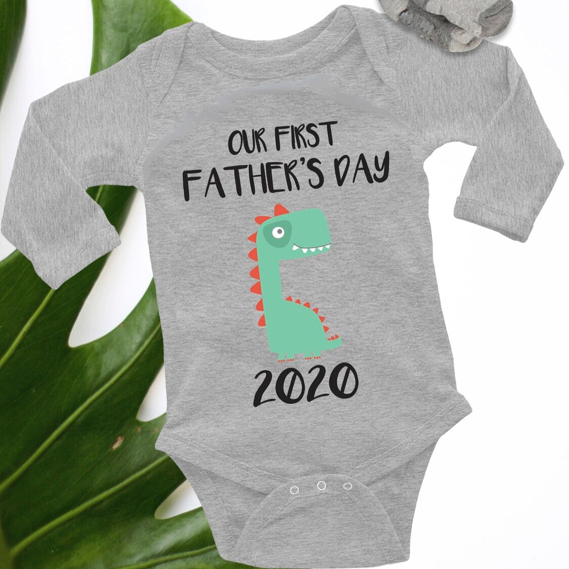 Personalised Baby Onesie from Happy Look | South Africa – Featuring a fun dinosaur design with the words "OUR FIRST FATHER'S DAY 2020." Perfect for celebrating a new dad and not customisable. A thoughtful gift that brings joy and lasting memories. Shop now!