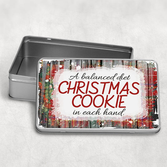 Rectangular Christmas Cookie Tin "A balanced diet CHRISTMAS COOKIE in each hand" from Happy Look | South Africa – A silver rectangular tin with its lid open, featuring a humorous text design over a rustic wood and red tartan background. The text reads: "A balanced diet CHRISTMAS COOKIE in each hand."