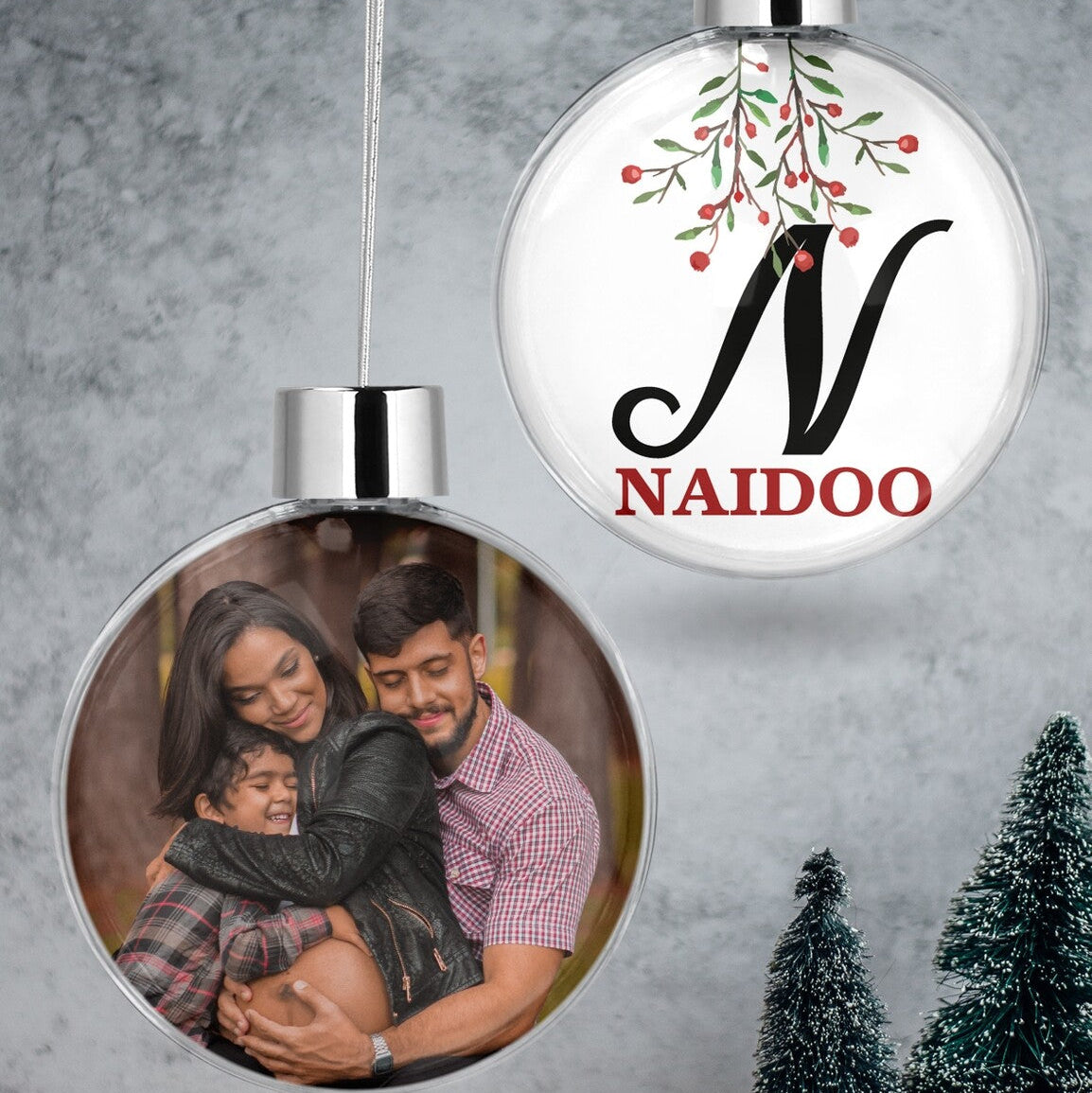 Custom Photo & Initial Christmas Bauble "N Naidoo" from Happy Look | South Africa – A clear hanging Christmas bauble set. One bauble features a loving family photo, and the other displays a large black initial 'N' and "NAIDOO" in red, with a festive branch design.