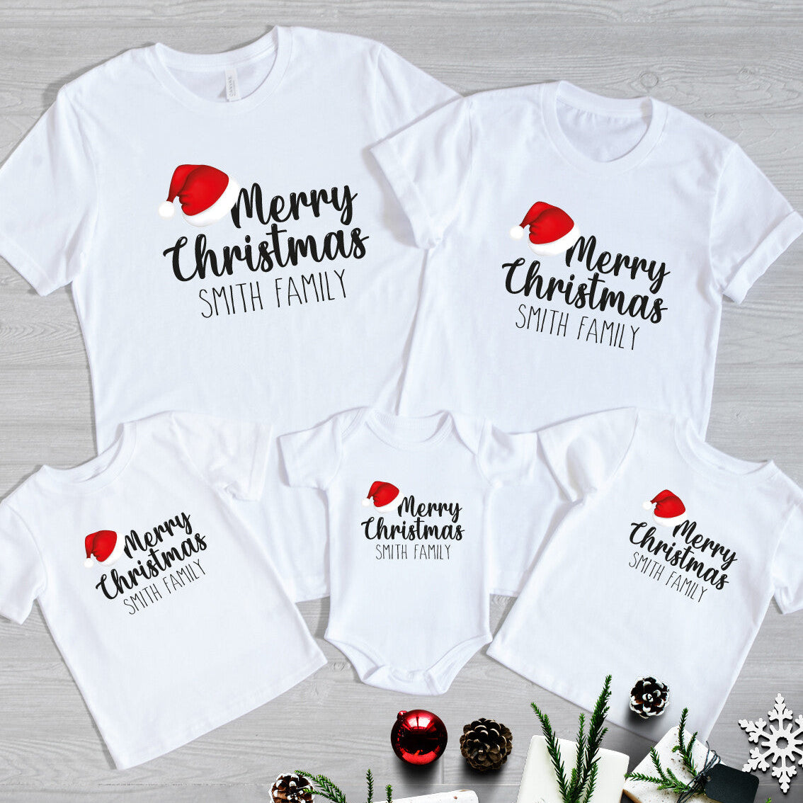 Personalised Family Christmas T-Shirts from Happy Look | South Africa – Matching white t-shirts and baby grow featuring “Merry Christmas Smith Family” with a festive red Santa hat. A joyful family outfit for the holidays, perfect for Christmas photos, family gatherings, and festive gifting. Celebrate the season in style with custom Christmas apparel that spreads love and cheer.