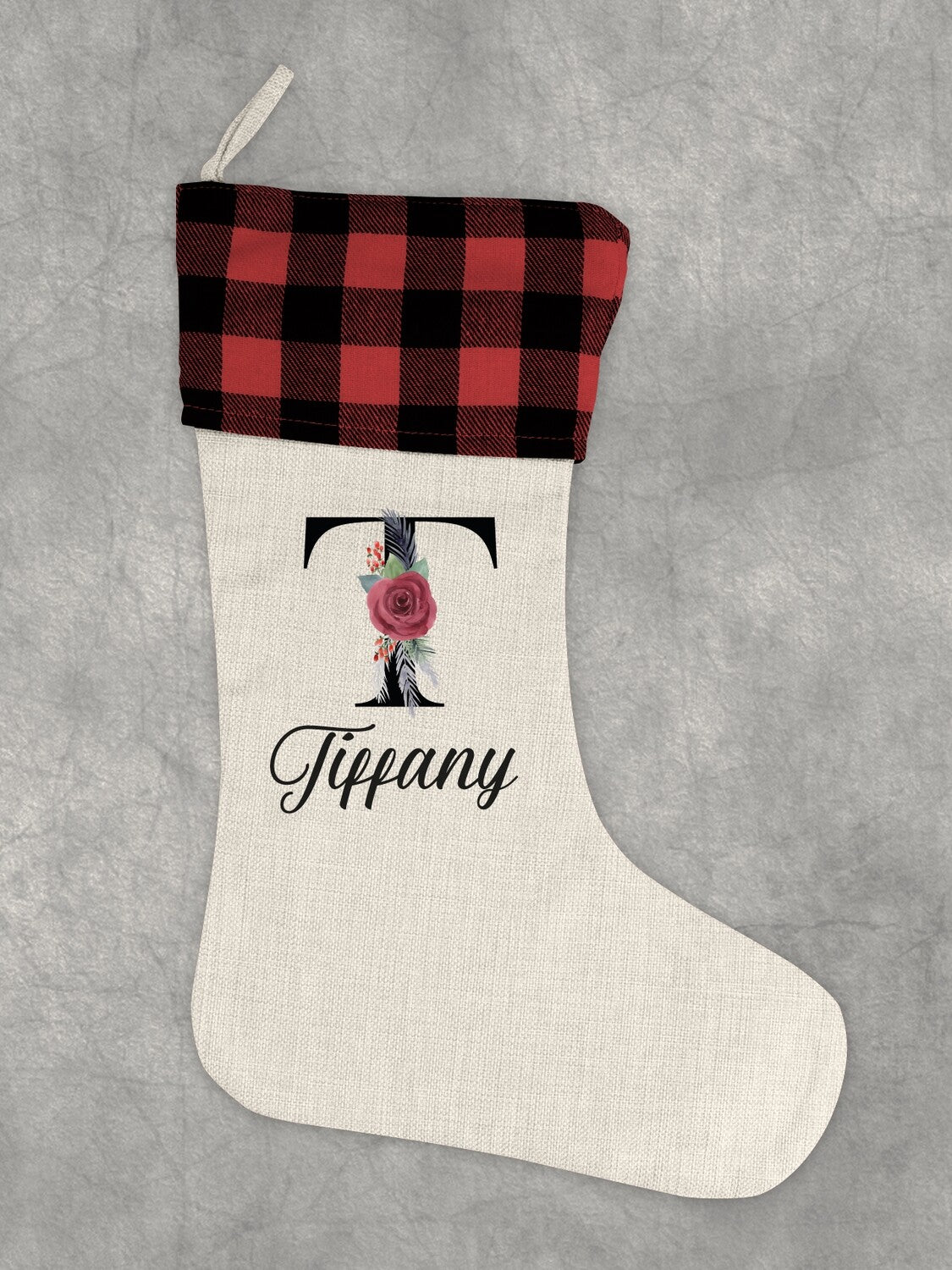 Personalised Christmas Stocking "Tiffany" with Floral Initial from Happy Look | South Africa – A single cream-colored stocking with a red and black buffalo plaid cuff. It features a large black initial 'T' decorated with a red rose and greenery, and the name "Tiffany" below in script.