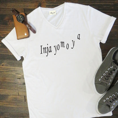 White t-shirt with text on a wooden surface with shoes and a watch.