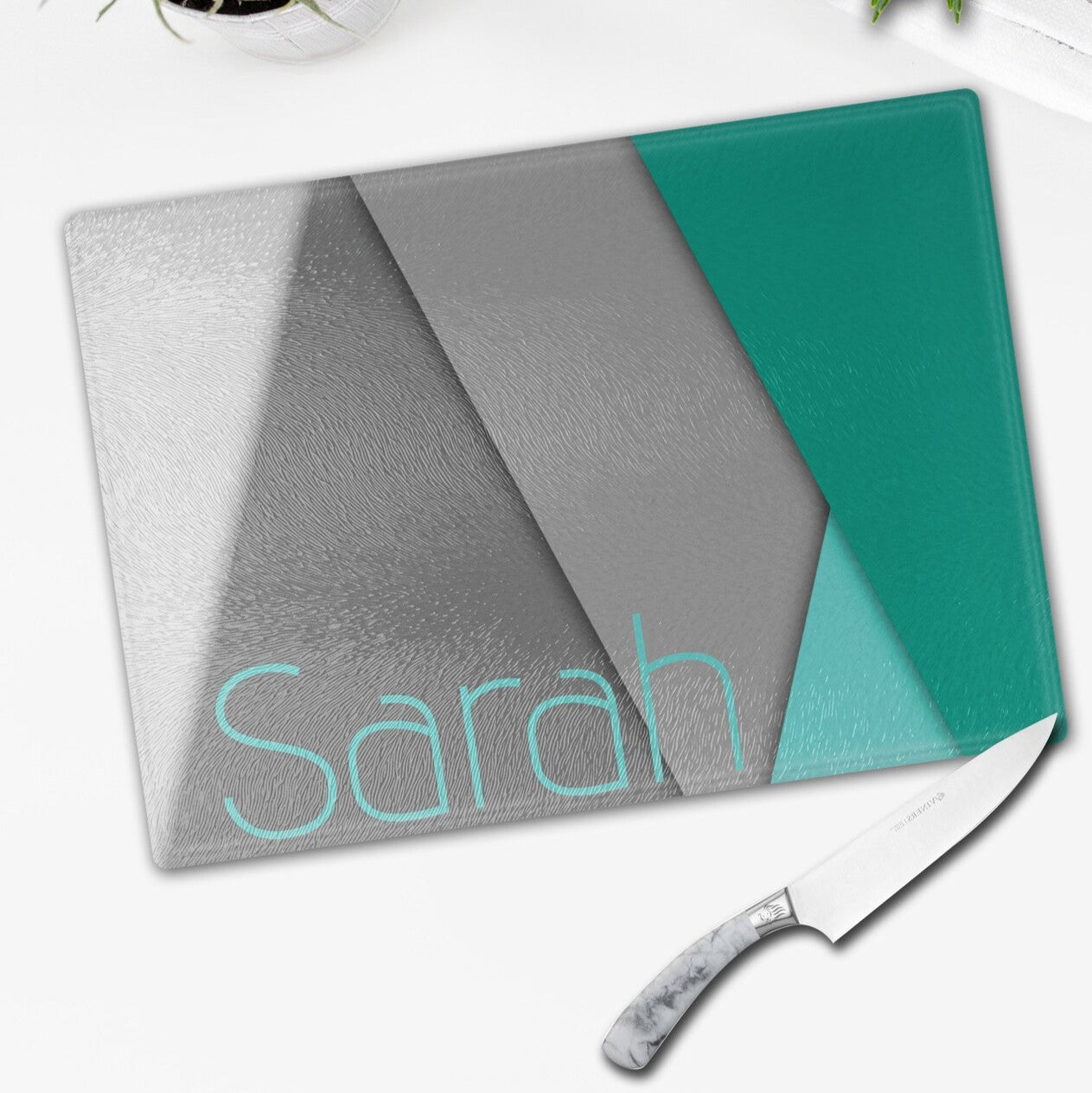 ersonalised Glass Cutting Board from Happy Look | South Africa – A personalised cutting board featuring a modern geometric design in gray and teal, with the name "Sarah" prominently displayed. Perfect for birthdays, housewarmings, or special occasions and customisable with a name or personal message. A thoughtful gift that brings joy and lasting memories. Shop now!