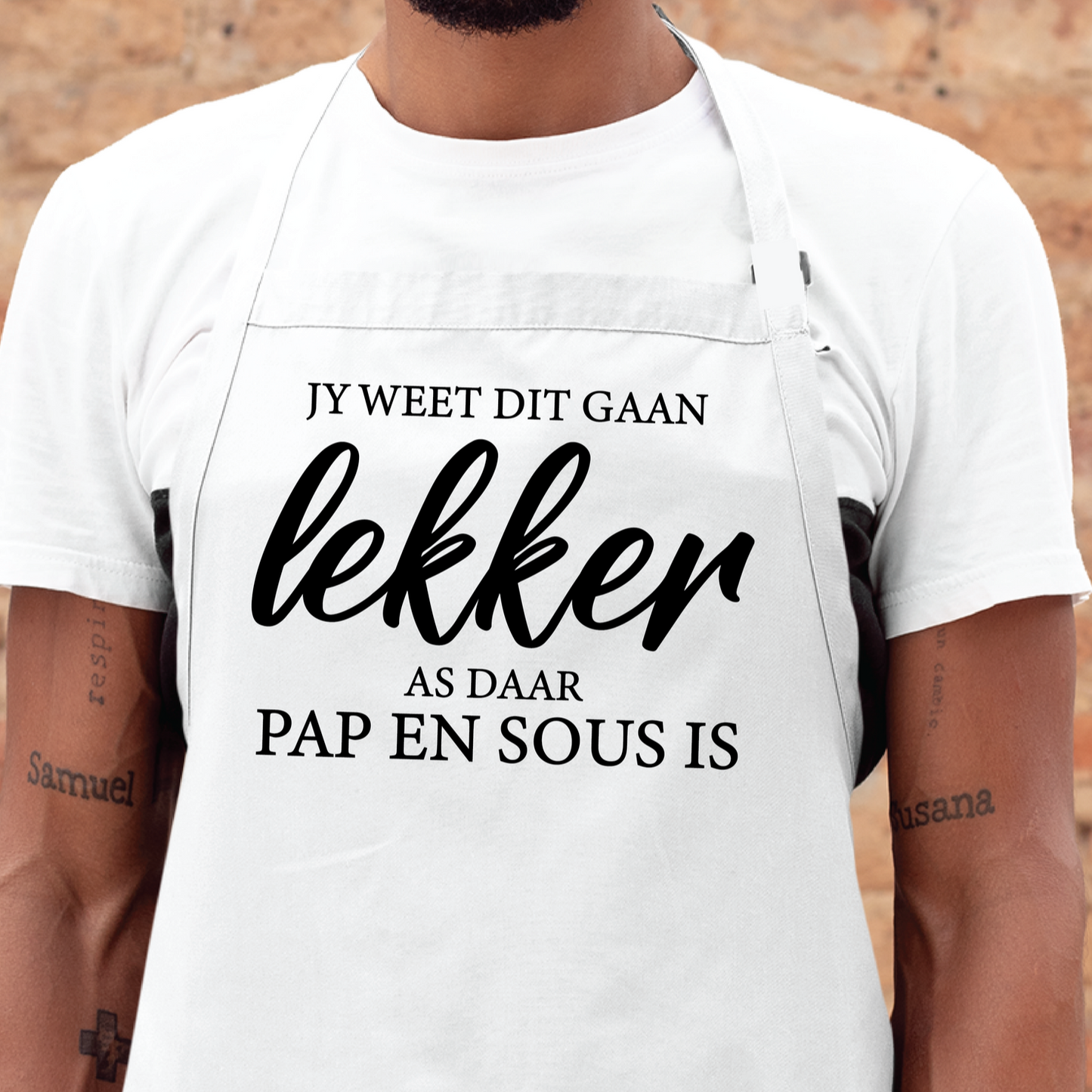 Personalised apron from Happy Look | South Africa – A chic white apron adorned with the phrase "jy weet dit gaan lekker as daar pap en sous is". Perfect for traditional cooking events and festive occasions, and customisable with personal designs. A thoughtful gift that brings joy and lasting memories. Shop now!
