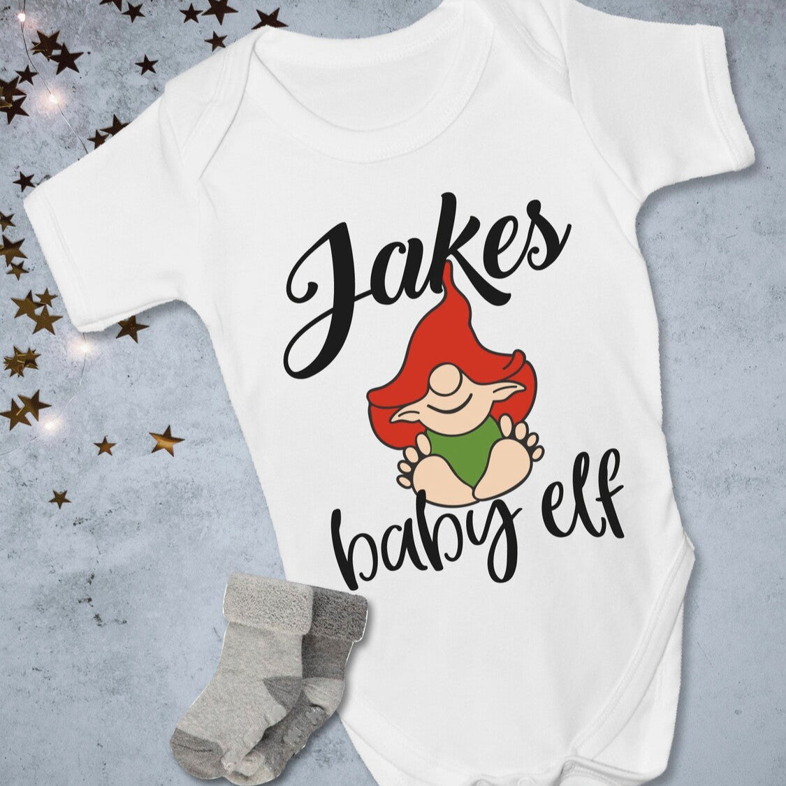 Personalised baby elf onesie from Happy Look | South Africa – features a cute elf graphic with the name "Jake." Perfect for Christmas celebrations and customisable with unique names. A thoughtful gift that brings joy and lasting memories. Shop now!