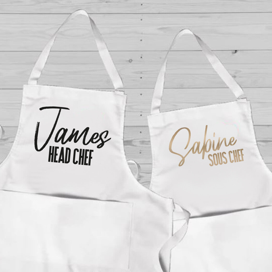 Personalised Couples Apron Set from Happy Look | South Africa – Professional chef-themed design, featuring "James" as Head Chef and "Sabine" as Sous Chef. Perfect for culinary enthusiasts and special occasions, customisable with names. A thoughtful gift that brings joy and lasting memories. Shop now!