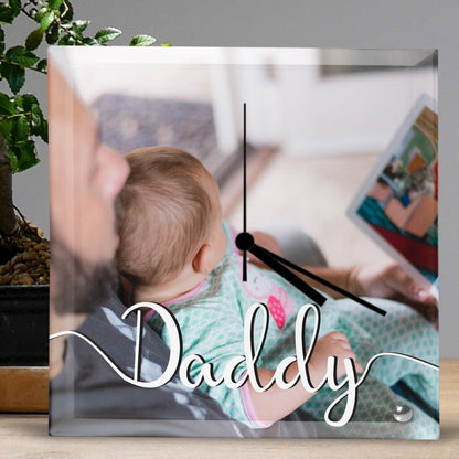Square Glass Clock featuring a photo of a man reading to a baby on his lap, with the word 'Daddy' in script. Personalised Square Glass Clock from Happy Look | South Africa – A touching and meaningful clock that celebrates fatherhood. Perfect for Father's Day, birthdays, or special moments, and customisable with your own personal message. A thoughtful gift that brings joy and lasting memories. Shop now!