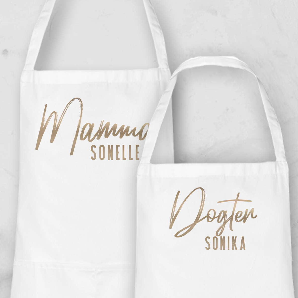 Personalised Apron Set from Happy Look | South Africa

Features two white aprons with custom names: "Mammo Sonelle" and "Dogter Sonika."
Perfect for family occasions and customisable with unique names or titles.
A thoughtful gift that brings joy and lasting memories. Shop now!