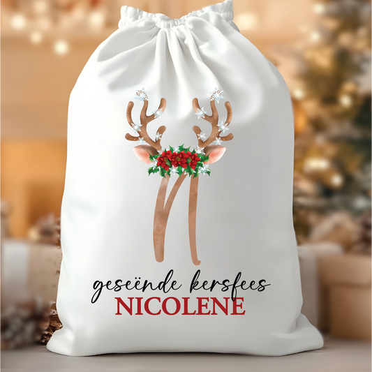 Personalised Afrikaans Santa Sack "geseënde kersfees NICOLENE" from Happy Look | South Africa – A large white drawstring Christmas gift bag with a watercolor reindeer antler and holly design, and the Afrikaans text: "geseënde kersfees NICOLENE."