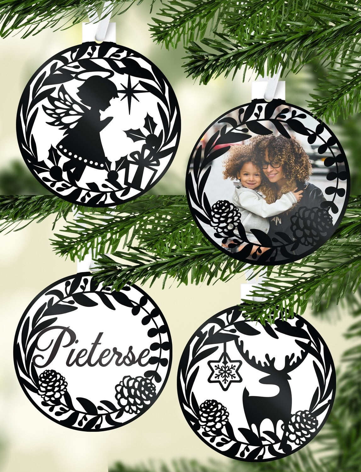 Silhouette Filigree Christmas Bauble Set "Pieterse" from Happy Look | South Africa – A set of four white, circular ornaments with intricate black filigree designs. The set includes a mother and child photo, a reindeer and snowflake silhouette, a silhouette of an angel with a gift, and the family name "Pieterse."