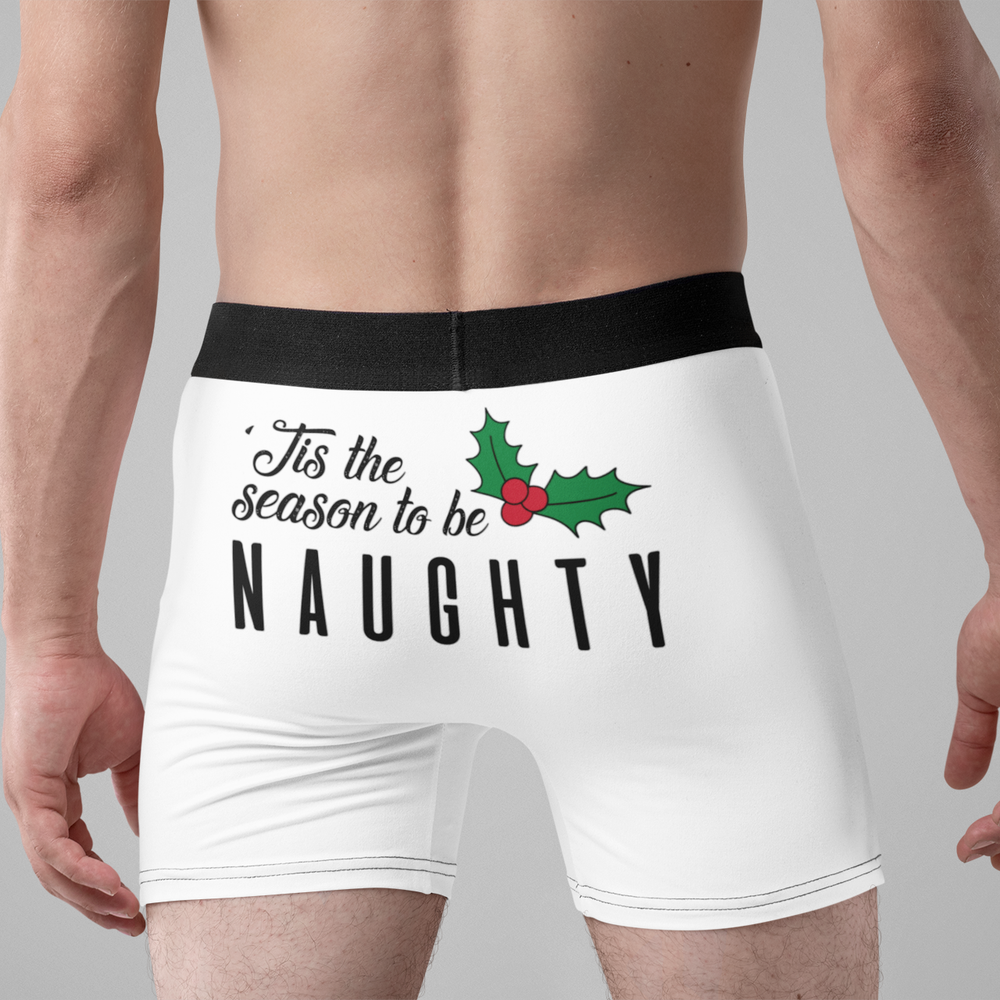 Men's Christmas Boxer Briefs "Tis the season to be NAUGHTY" from Happy Look | South Africa – White boxer briefs worn by a man, featuring a humorous Christmas design on the rear with a holly accent and the text: "’Tis the season to be NAUGHTY."