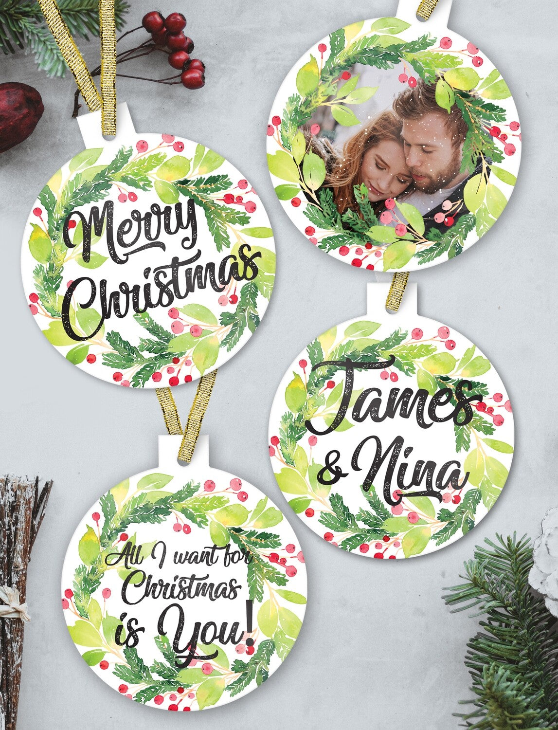 Couple Christmas Bauble Set "Merry Christmas James & Nina" from Happy Look | South Africa – A set of four hanging circular ornaments with a white background and a watercolor wreath of green leaves and red berries. The set includes a couple's photo, "Merry Christmas," "James & Nina," and "All I want for Christmas is You!"